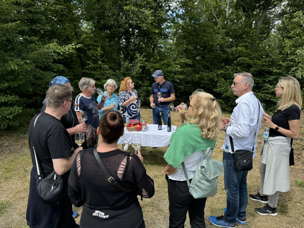 Wandergruppe bei einer Weinverkostung während einer PWW in den Weinbergen